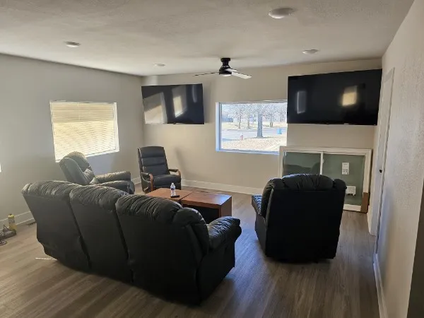 Cozy shared living room with couches and big screen TVs
